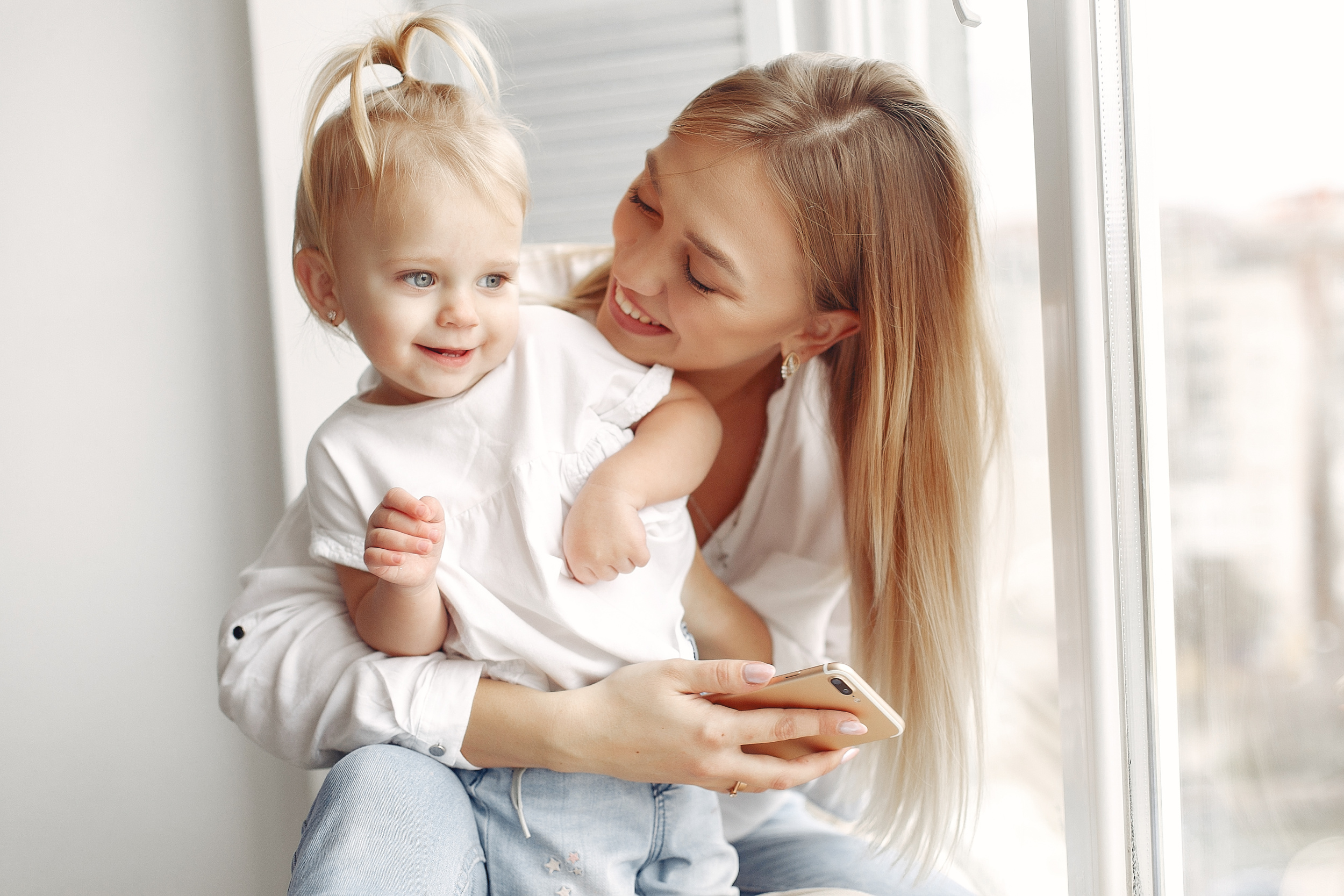 woman-uses-phone-mother-white-shirt-is-playing-with-her-daughter-family-has-fun-weekends.jpg